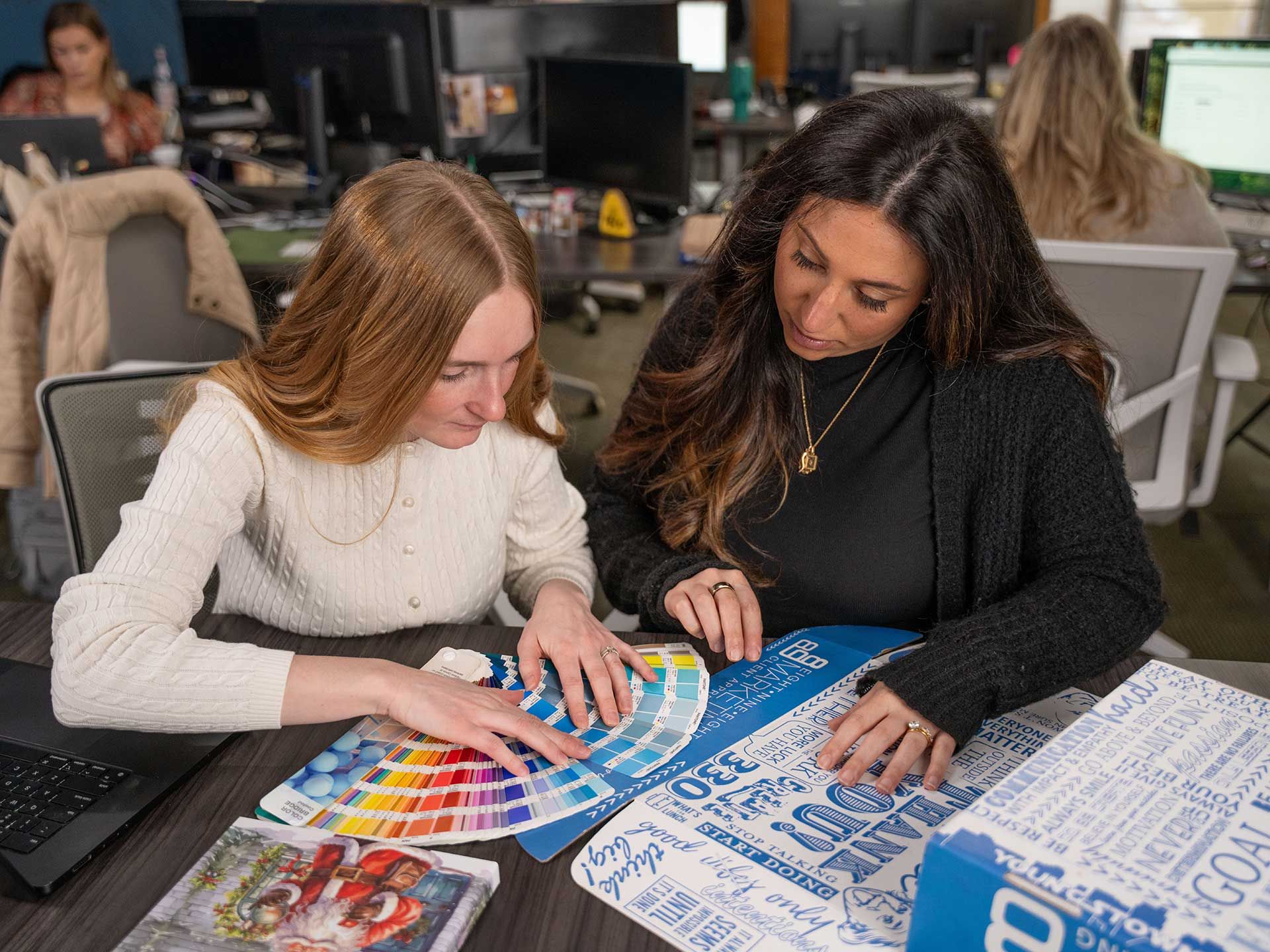 898 Marketing designers reviewing Pantone color swatches at their desk