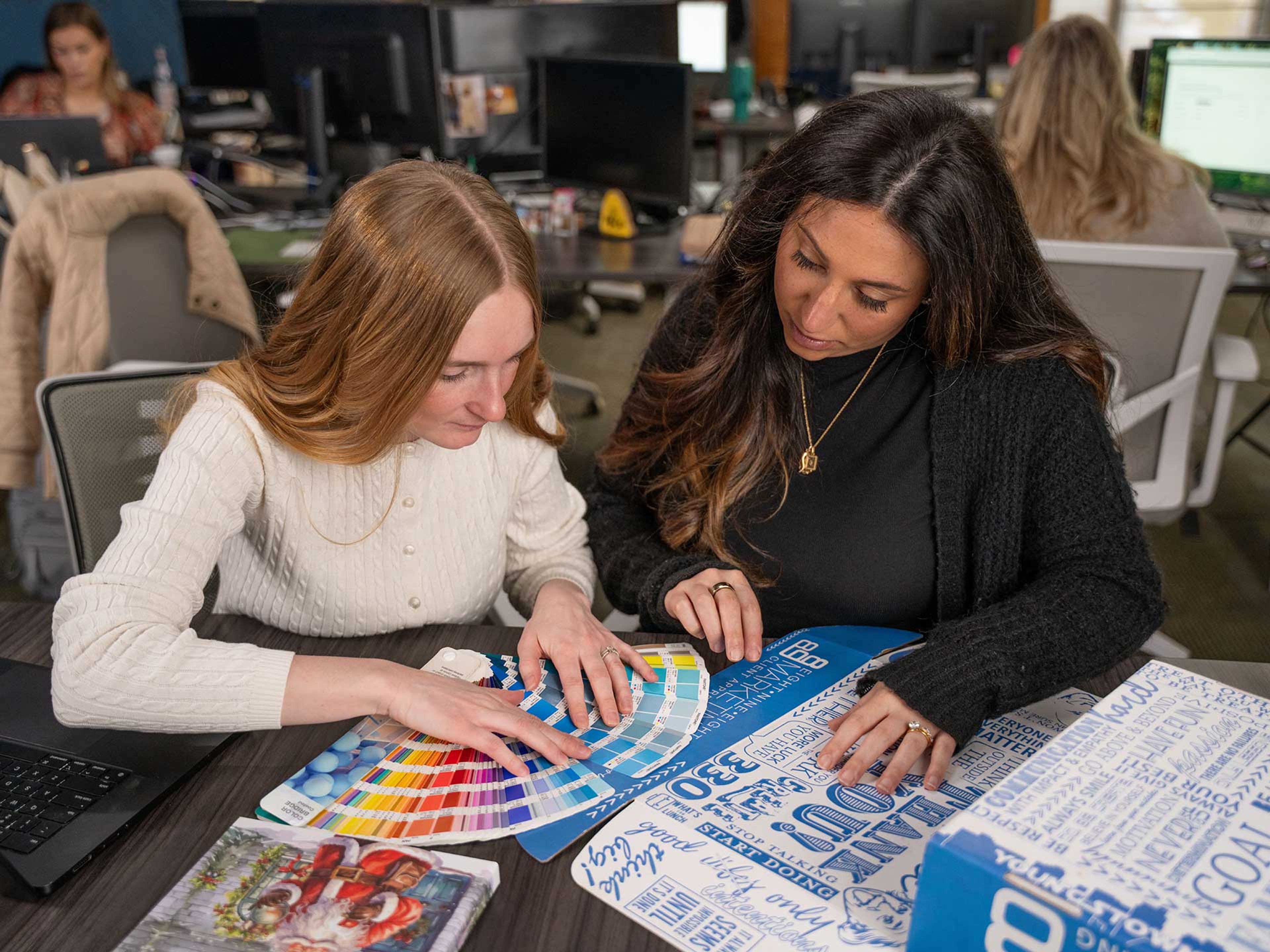 898 Marketing designers reviewing Pantone color swatches at their desk