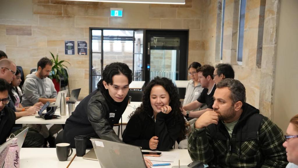 Three participants working something out together at a laptop.