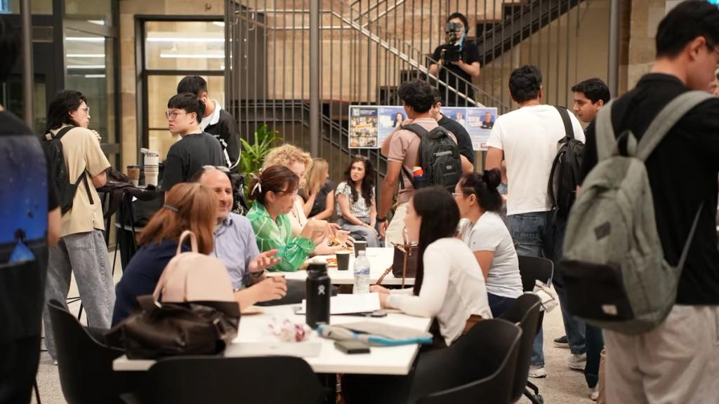 Attendees talking in the sandstone atrium between sessions.