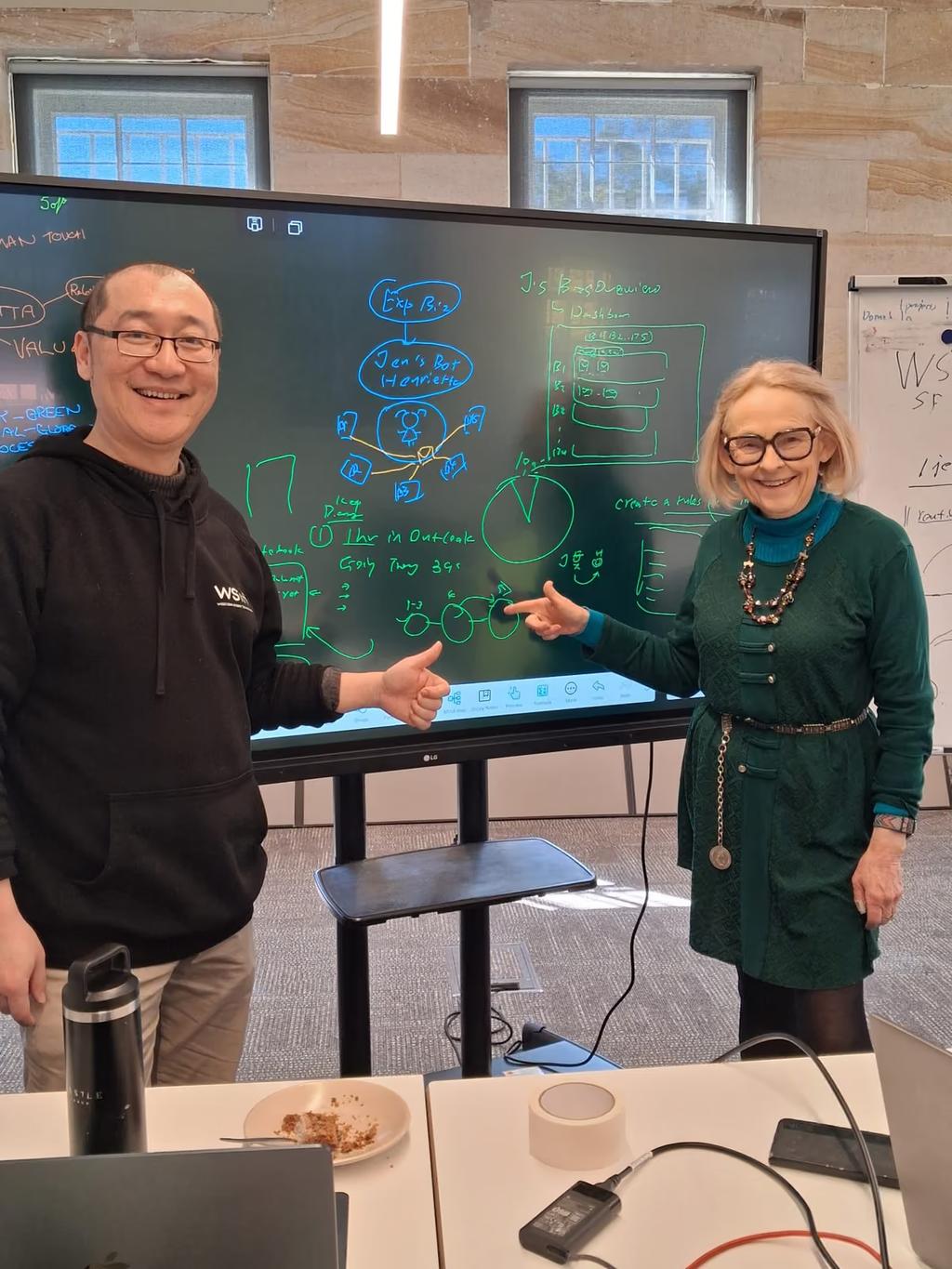 Jenetta Russell beside Lailei Huang at the screen, her automation mapped out behind them.