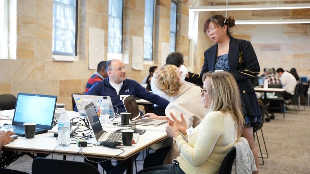 A mentor checking in with a table of participants.