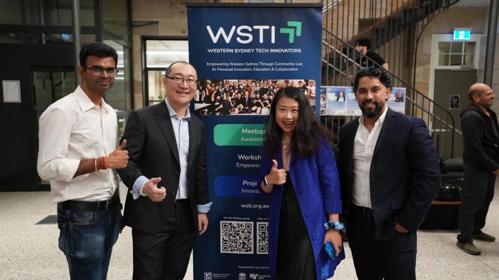 Four people from the WSTI team beside the banner after an event.