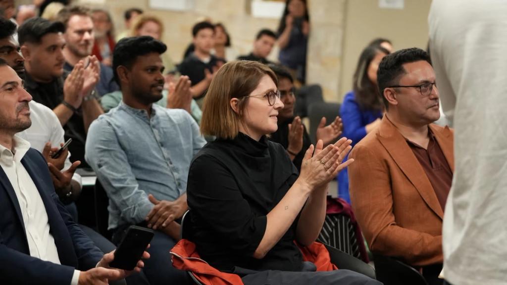 Attendees applauding at the end of a pitch.