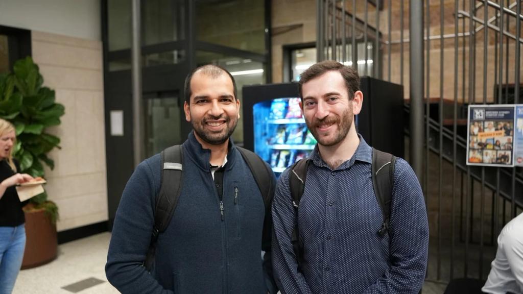 Two attendees compare notes at a community night