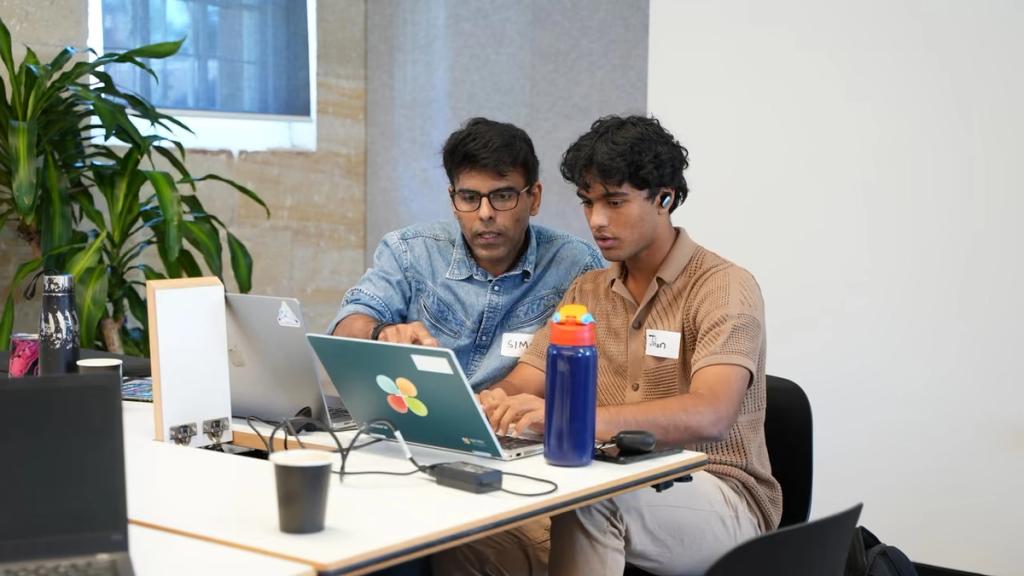 Two builders working together on a laptop.