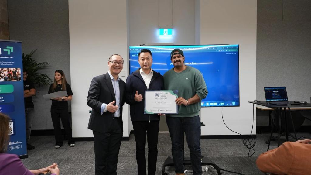 A team receives their certificate on stage at the Grand Finale pitch night