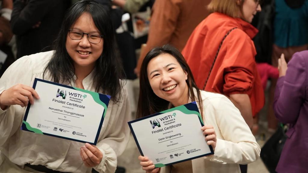 Two finalists holding their WSTI certificates.