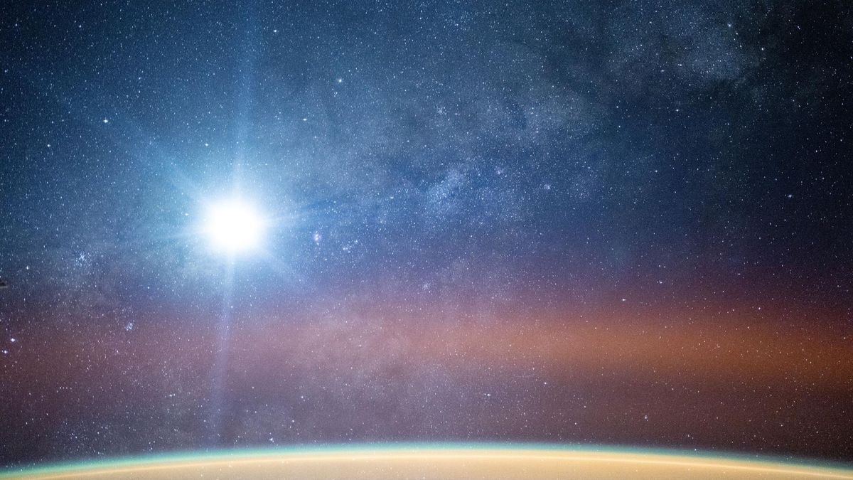 La Via Lattea illumina il cielo notturno sopra l'orizzonte terrestre