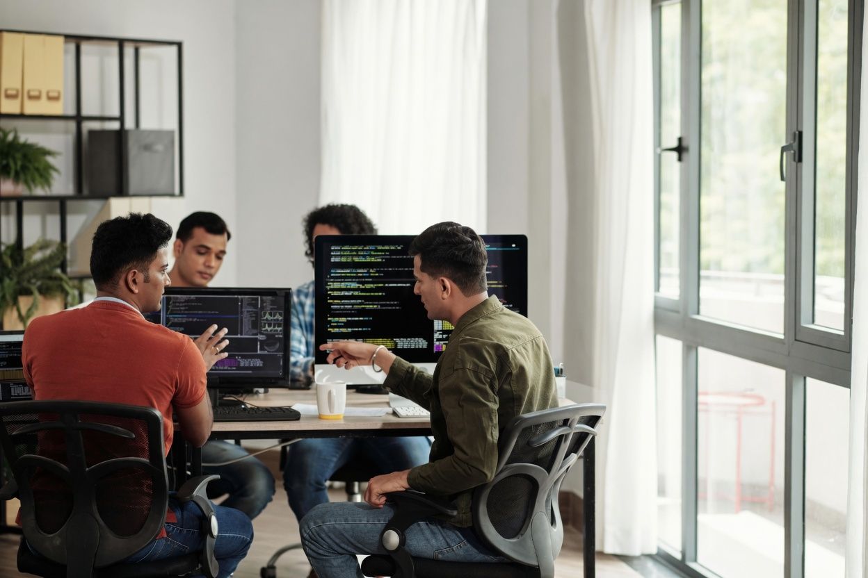Engineers reviewing code together on dual monitors
