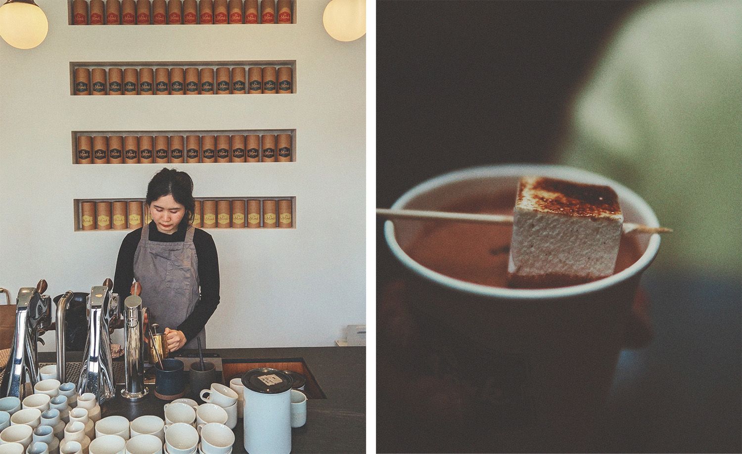 Two scenes from Mörk chocolate café in North Melbourne: on the left, a barista in a grey linen apron pouring from a golden kettle at the brew bar, rows of white ceramic cups arranged before her and walls of neatly ordered branded kraft paper cylinders displayed in recessed shelving behind, globe pendant lights glowing warmly above; on the right, a close-up of a rich dark hot chocolate served in a white ceramic bowl, a skewer bearing a perfectly toasted square marshmallow resting across the rim, capturing the considered craft and quiet pleasures of this celebrated chocolate house.