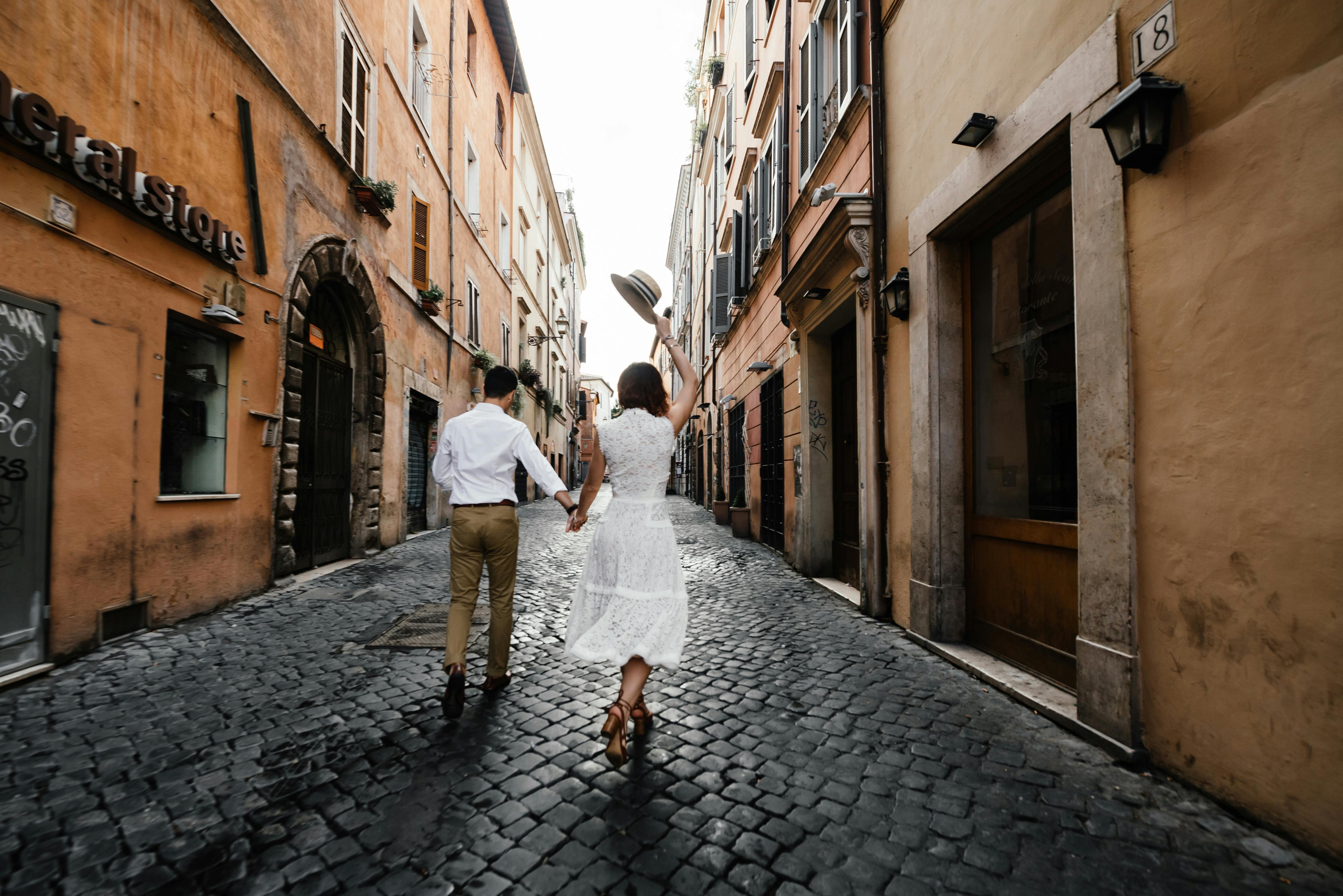 Couple walking down a cobblestone path in Italy for their destination wedding