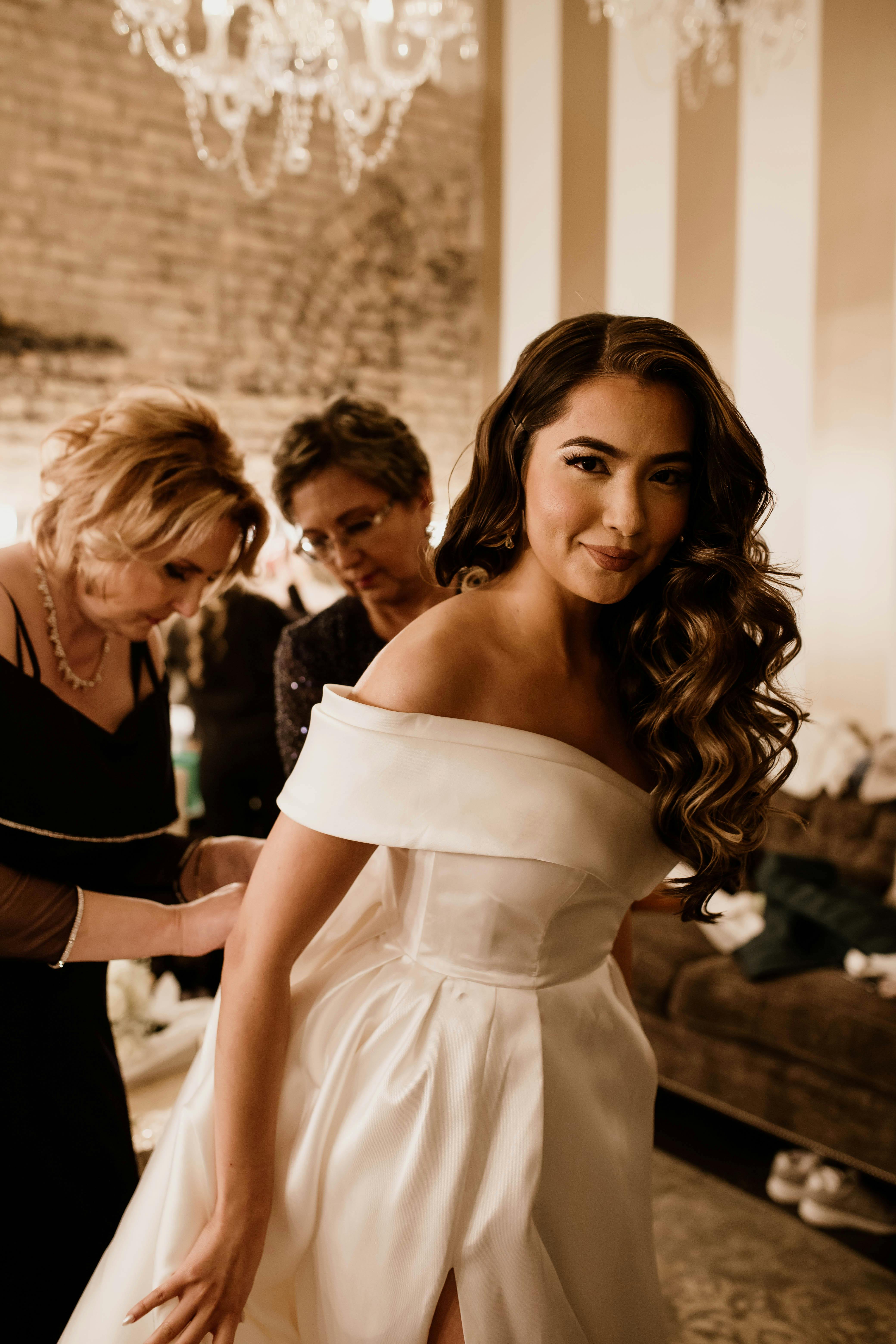 Mother of Bride and Mother of Groom help Bride with her dress at her destination wedding