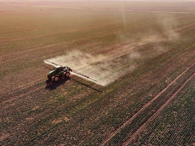 Tractor on Dead Field on Monoculture Crops