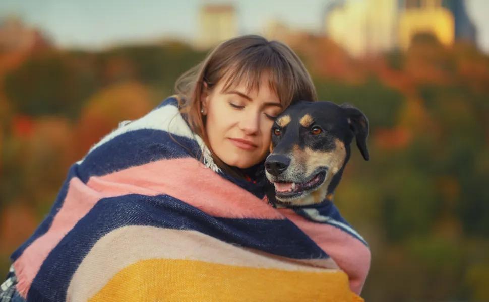 Woman Hugging Her Dog With a Blanket Around Them