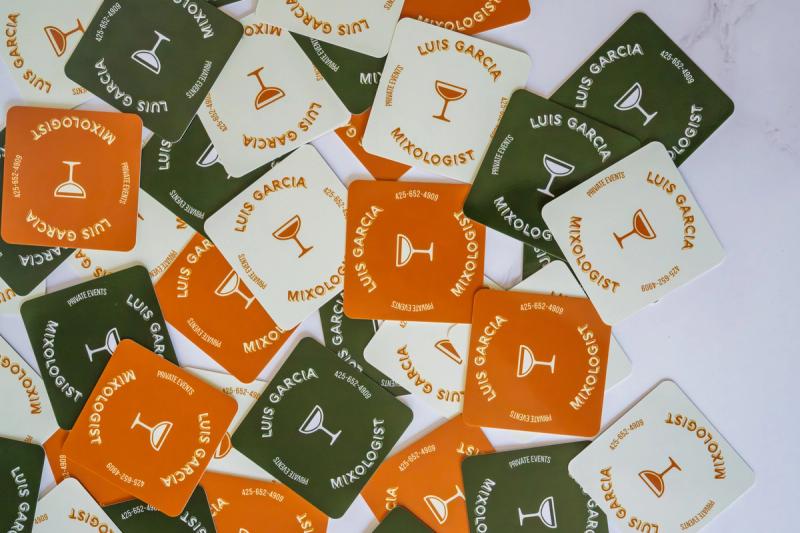 Scattered Luis Garcia business cards designed by YNOT CREATIVE on table