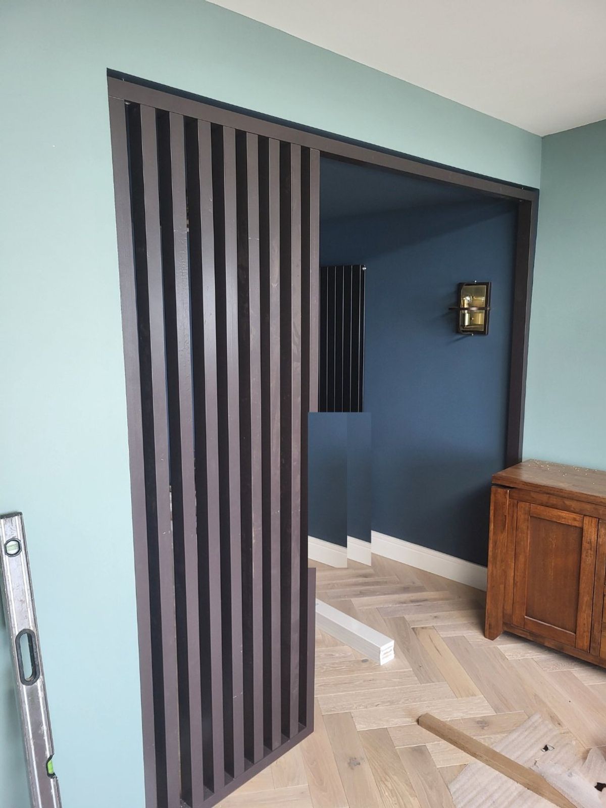 Bespoke slatted oak room divider with sliding doors