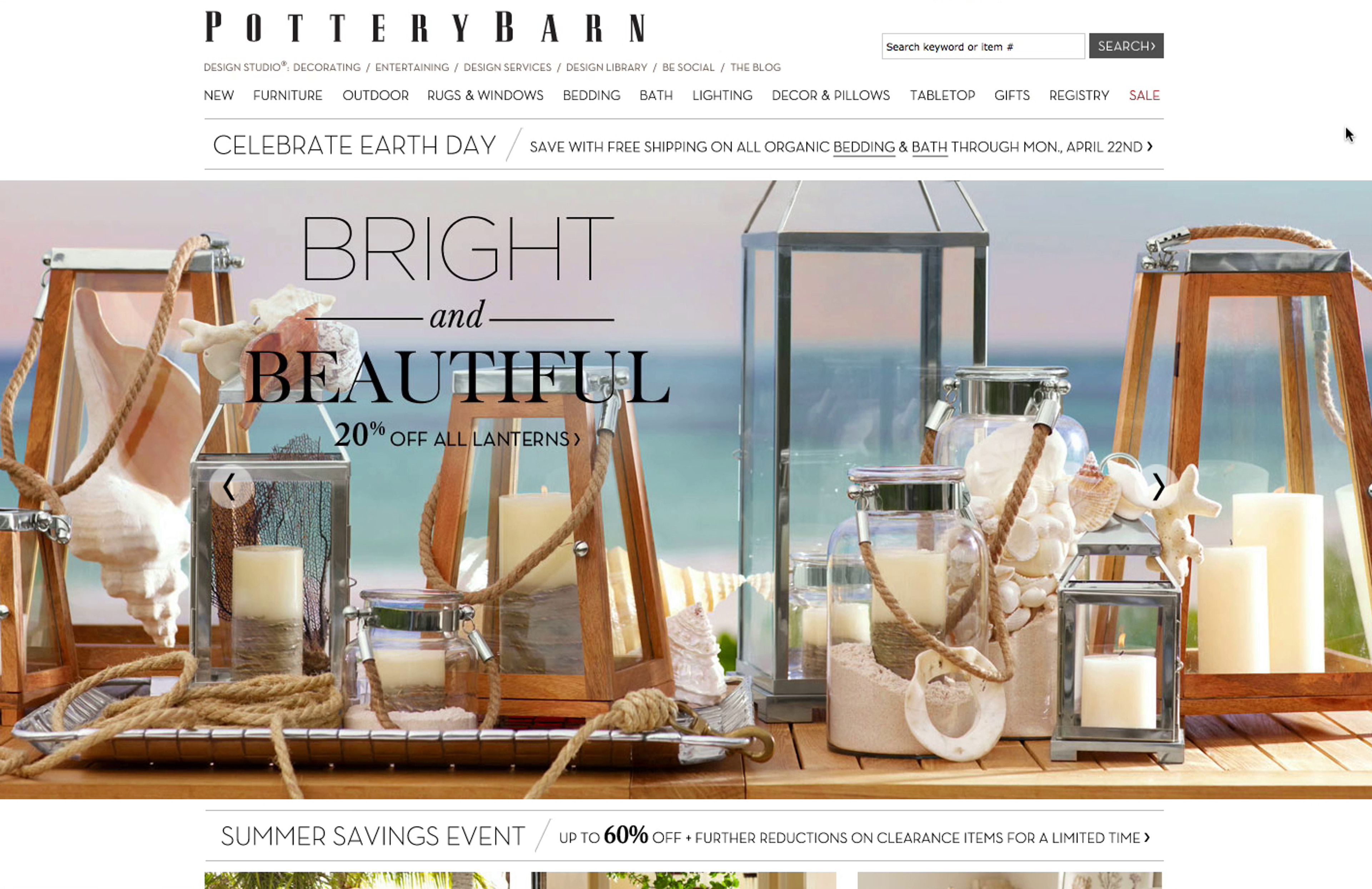 Pottery Barn homepage with high quality lifestyle imagery of lanterns on a table with the sea in the background