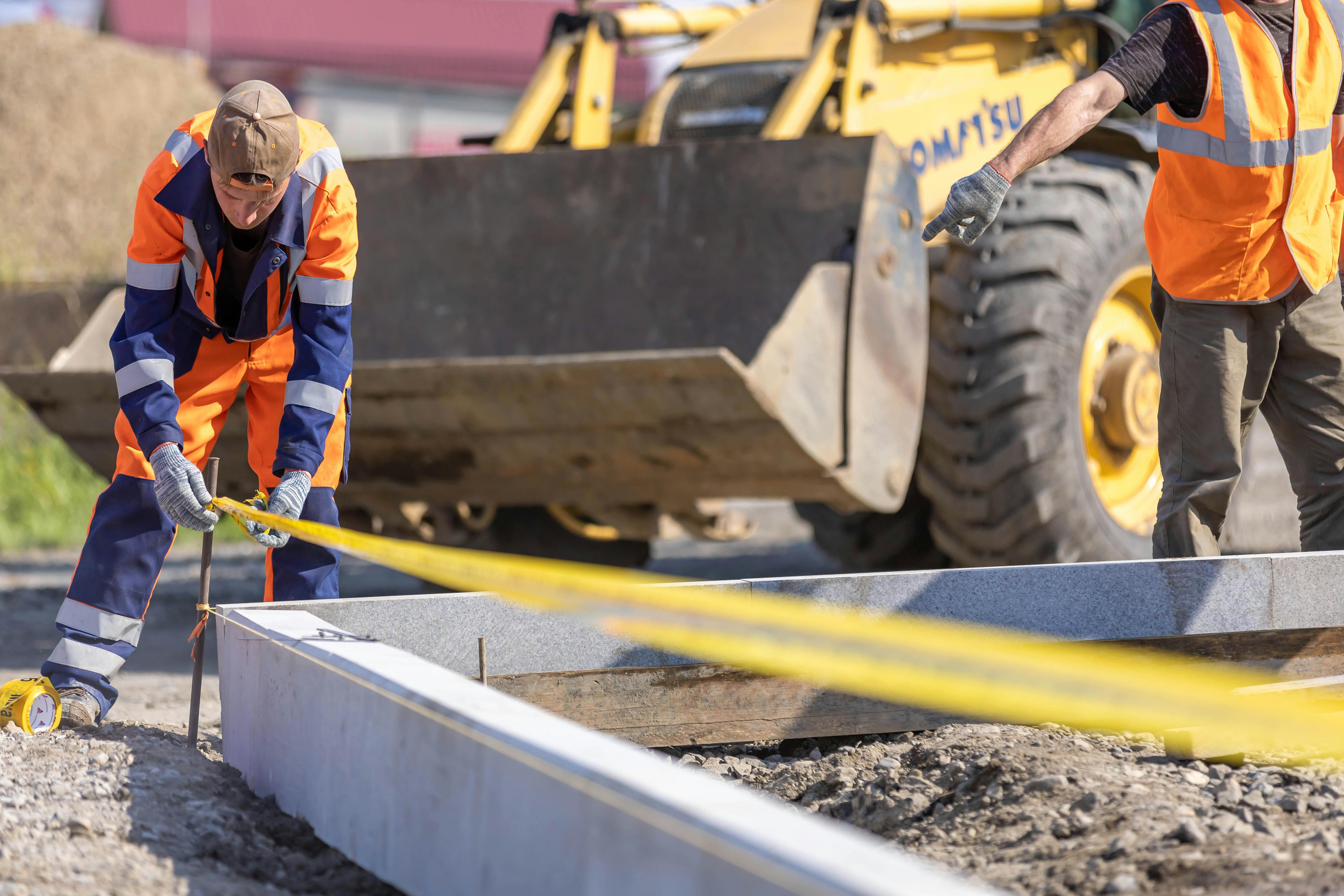 Construction workers on site with heavy machinery — equipment for Australian small business