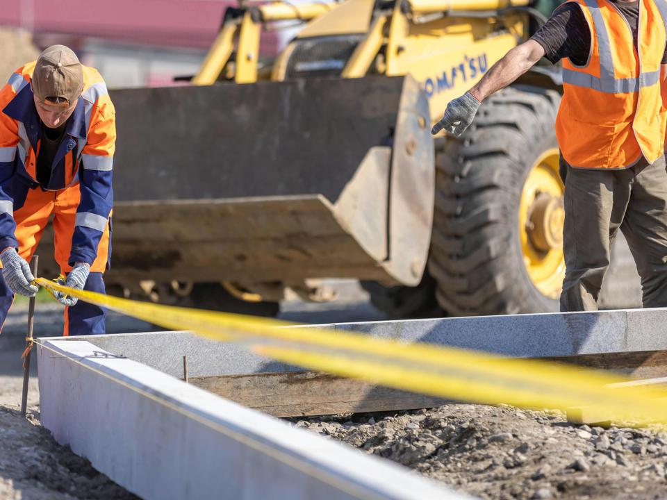Construction workers on site with heavy machinery — equipment for Australian small business