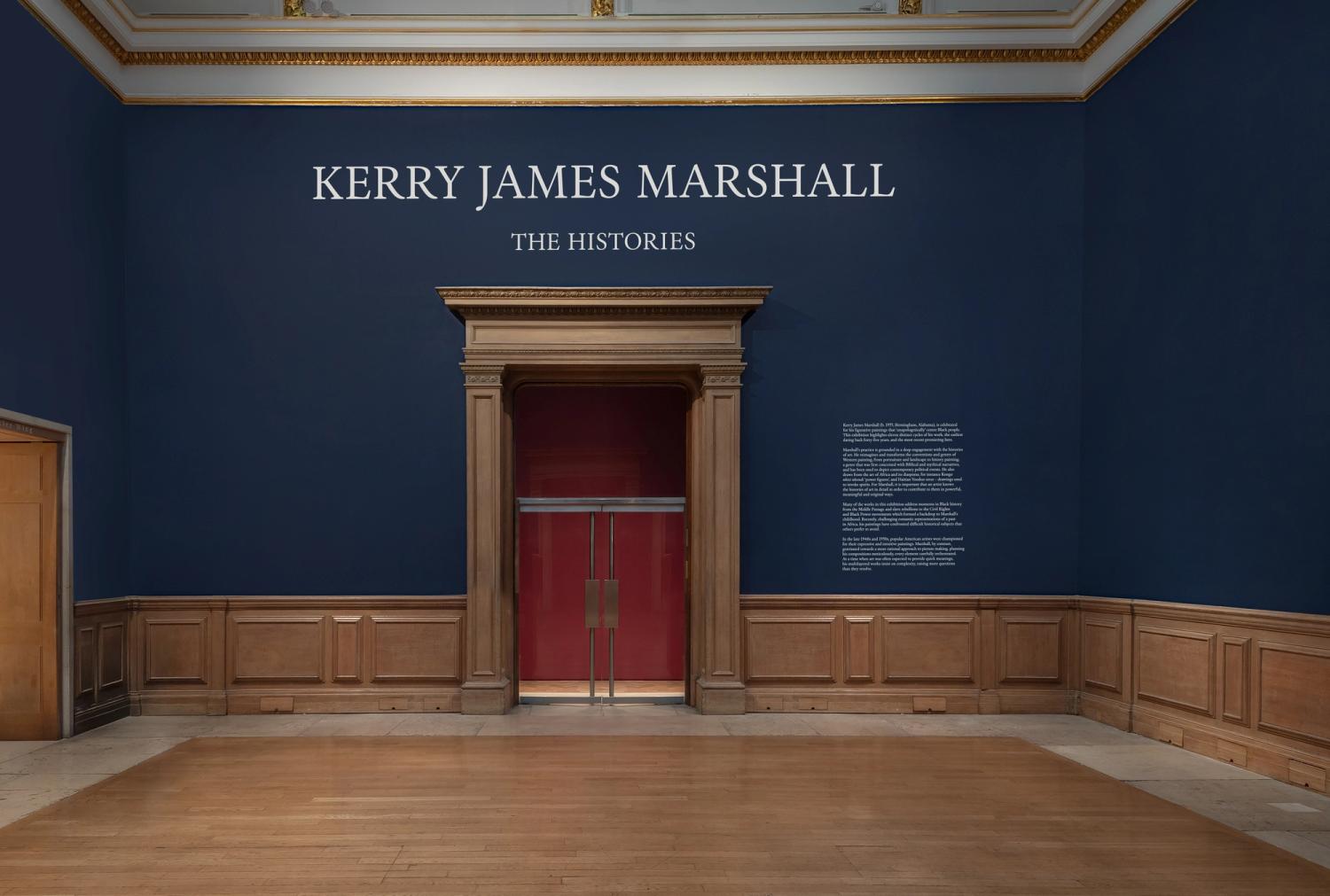 Exhibition entrance with dark blue walls, wooden doorway, and signage for Kerry James Marshall's "The Histories."
