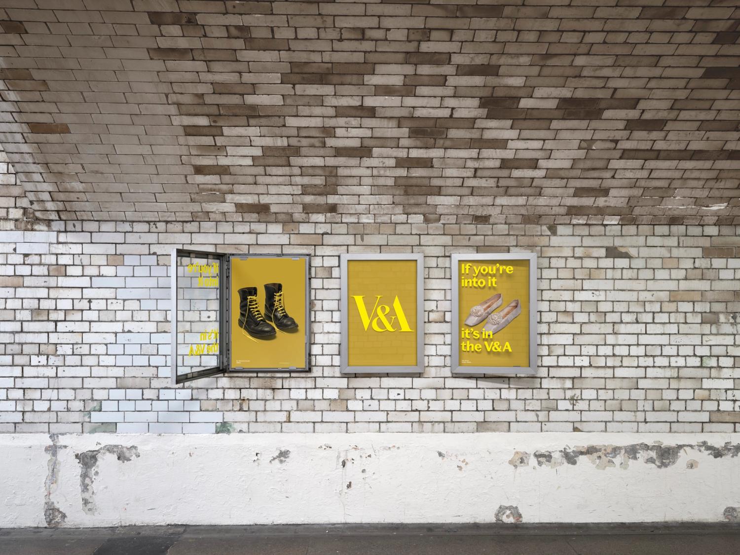A series of three posters in cases along the walls of a tiled tunnel. The posters are all mustard yellow, and the one on the far left has an open case.