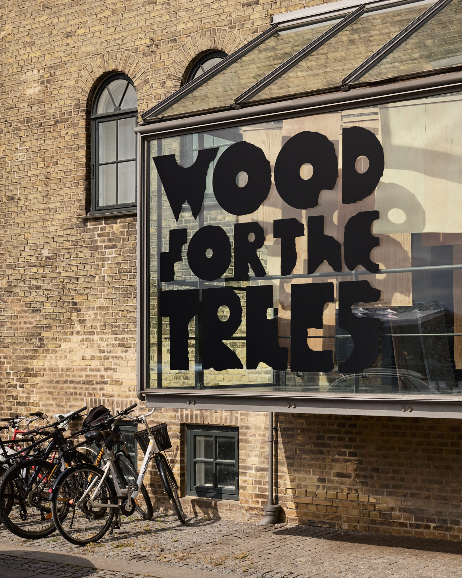 Black lettering on the external face of a large protruding window on a yellow brick docks building.