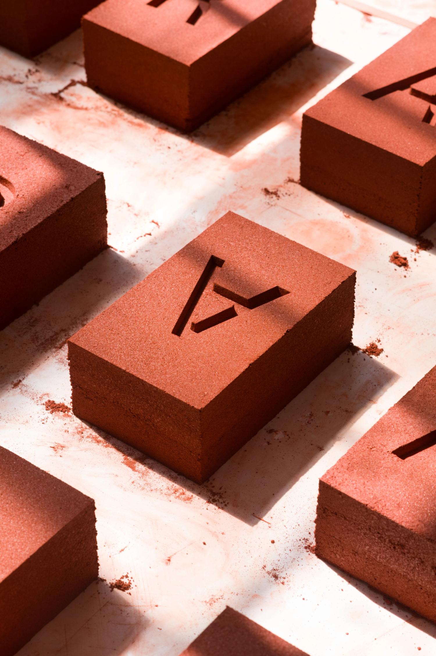Freshly-produced red bricks with 'A' stamped into them laid on the floor to dry
