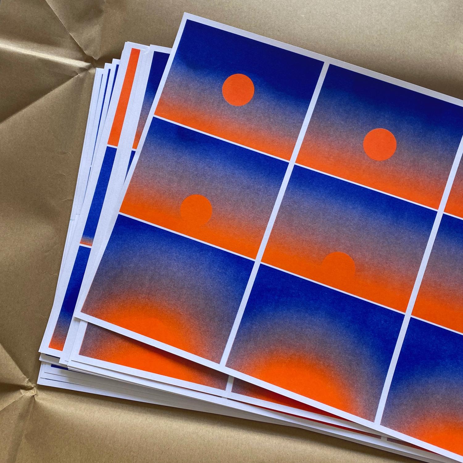 A stack of prints showing frames of a simple sunset animation in blue and orange ink.