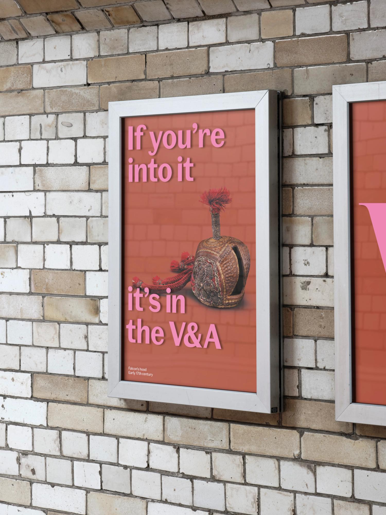 A red poster with a Roman helmet and pink text sits within a glass poster case on a tiled wall.