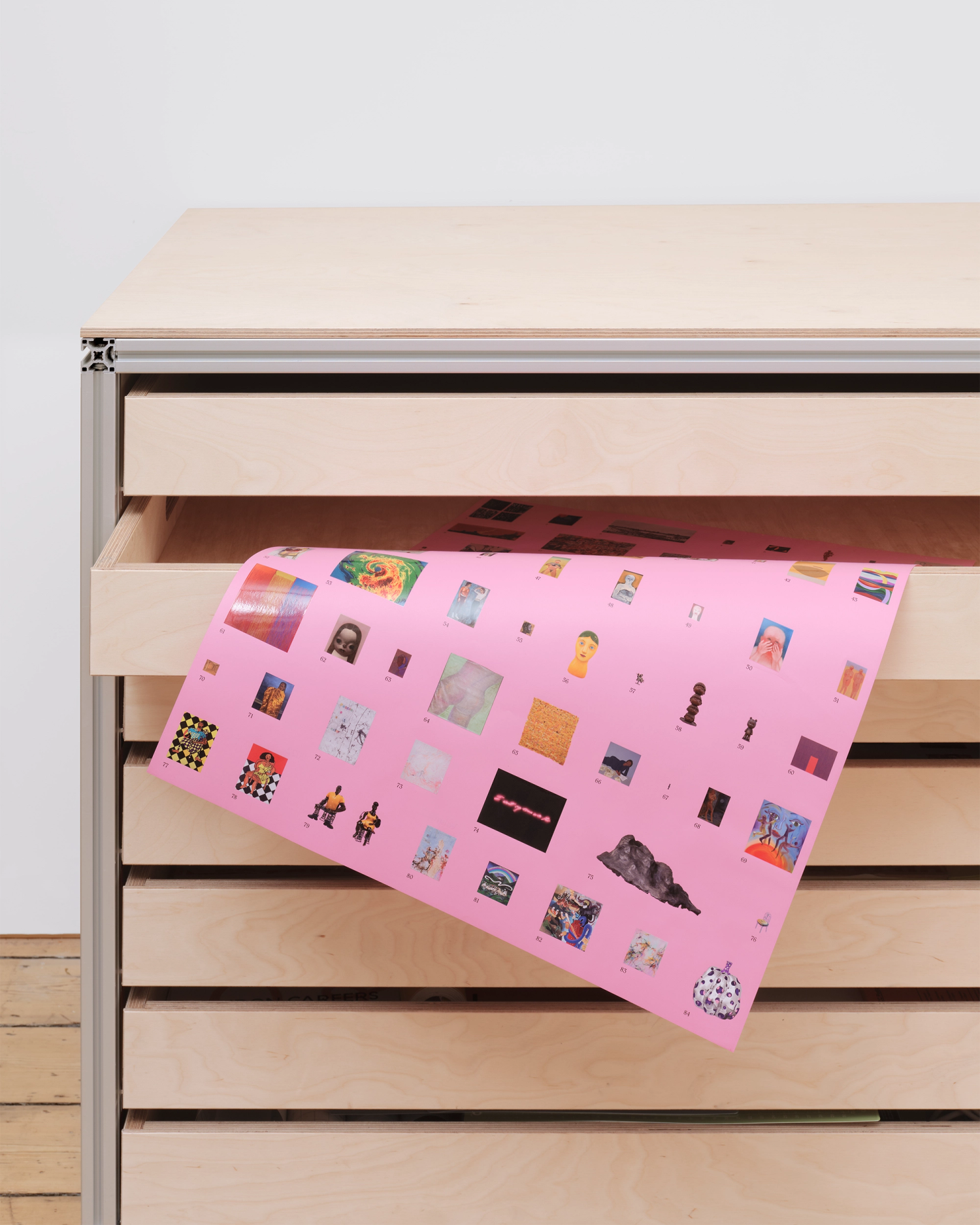 Photograph of a pink poster emerging from an open drawer in a plan chest