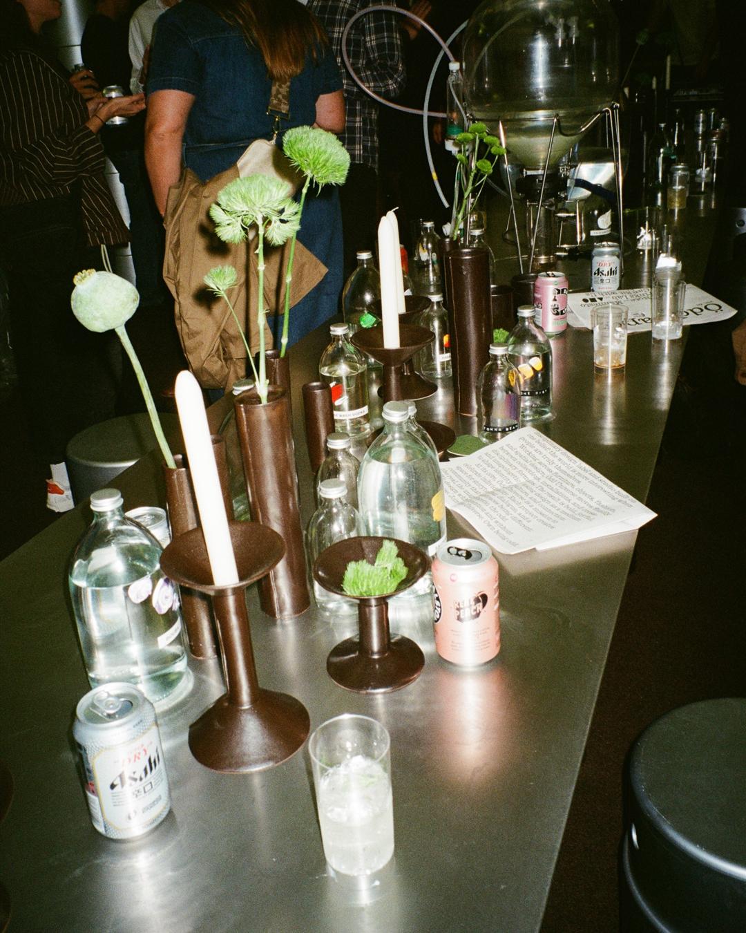 Table with drinks, vases, candles, and Ödd Paper at LDF 2025.