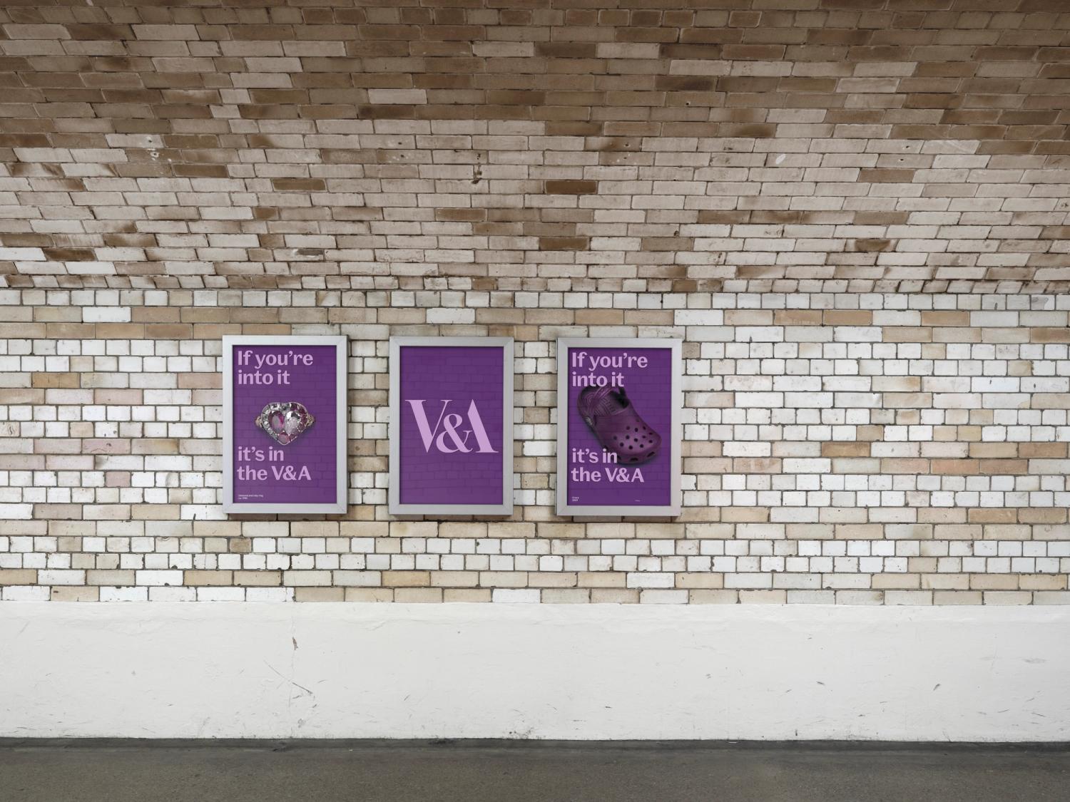 A set of three purple posters along the wall of a tiled underground tunnel. 