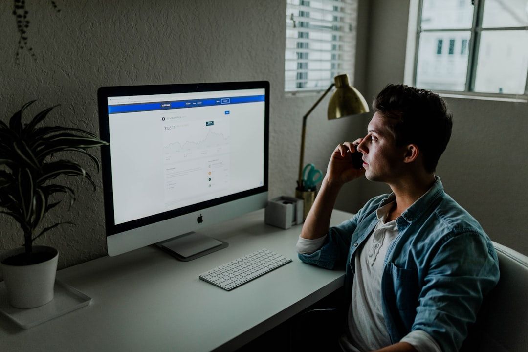 Man looking at his computer on his desk.