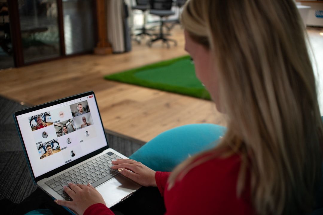 A woman sitting using her laptop to conduct a Team's meeting.