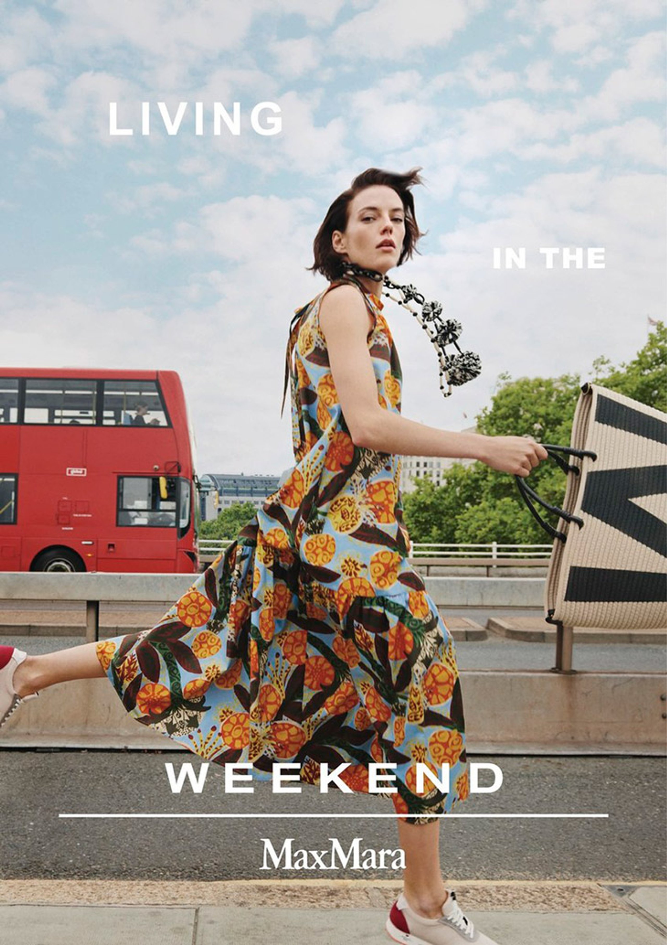 MaxMara Weekend Living In The Weekend campaign with model in tropical floral print dress running past red London bus