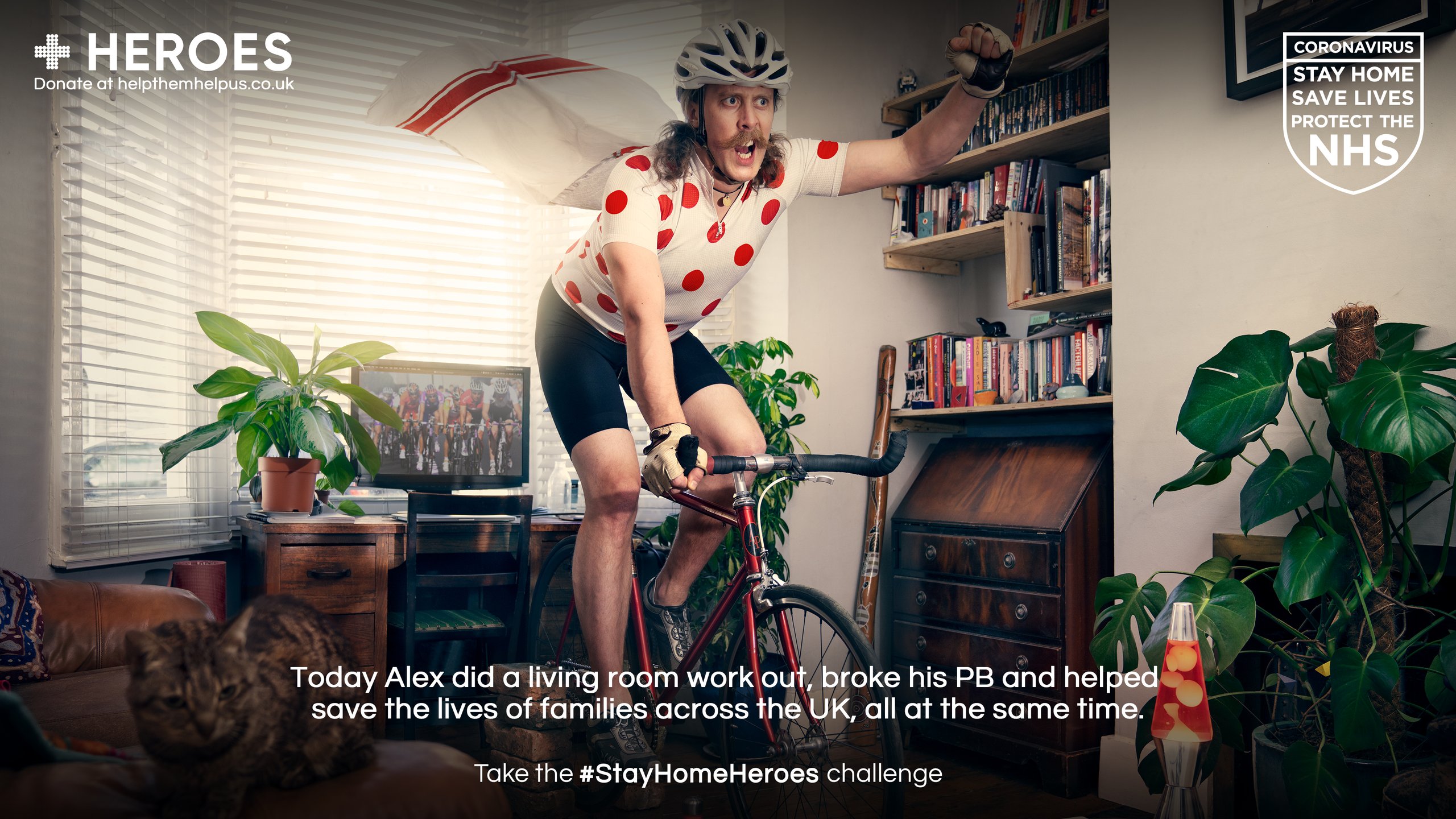 Man in polka dot cycling jersey on bicycle in living room for Stay Home Heroes campaign