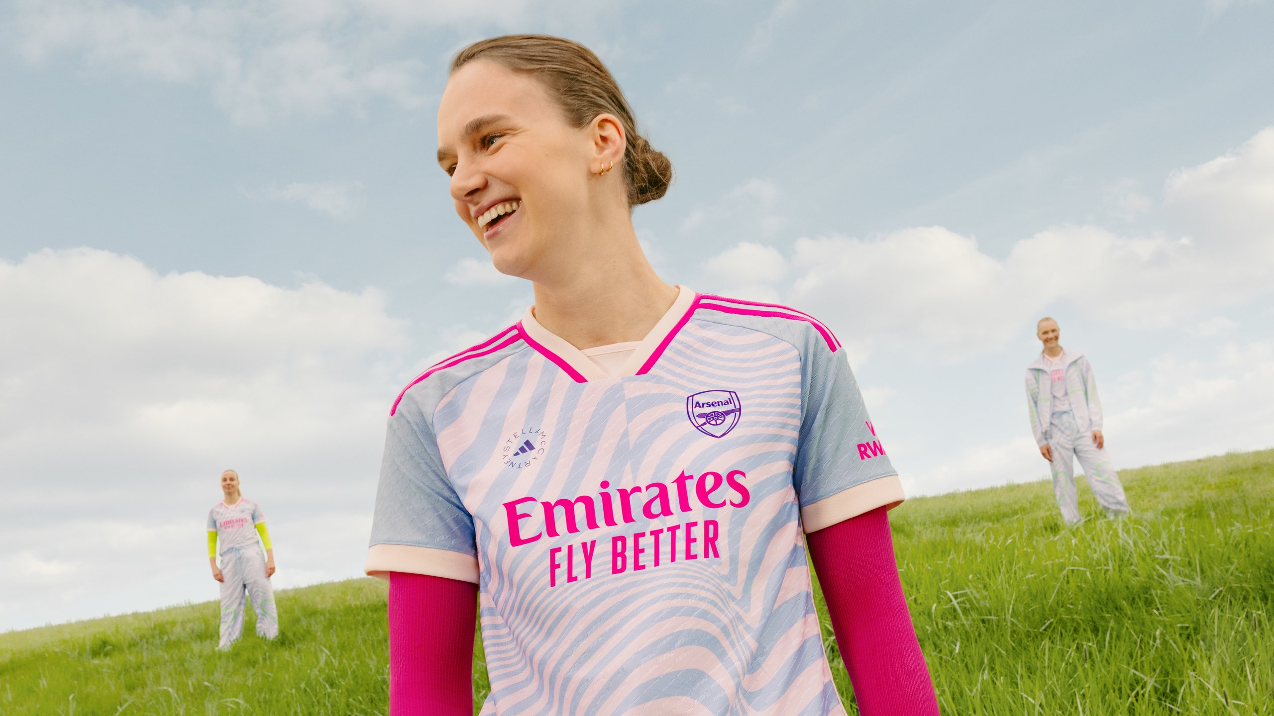 Arsenal Women player smiling in Stella McCartney pastel wave-print away shirt with Emirates Fly Better sponsor