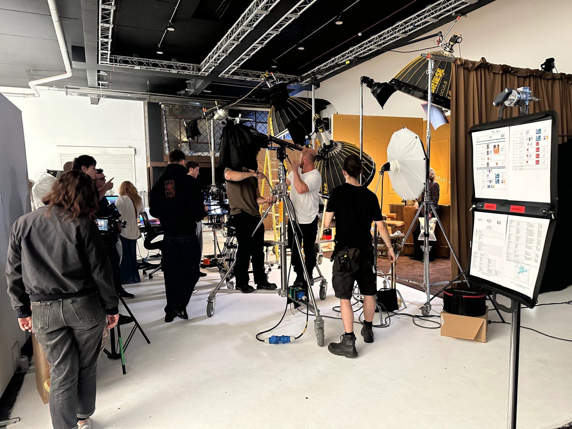 Wide shot of KETTLE Chips studio with full crew adjusting Briese lights and call sheet on display board