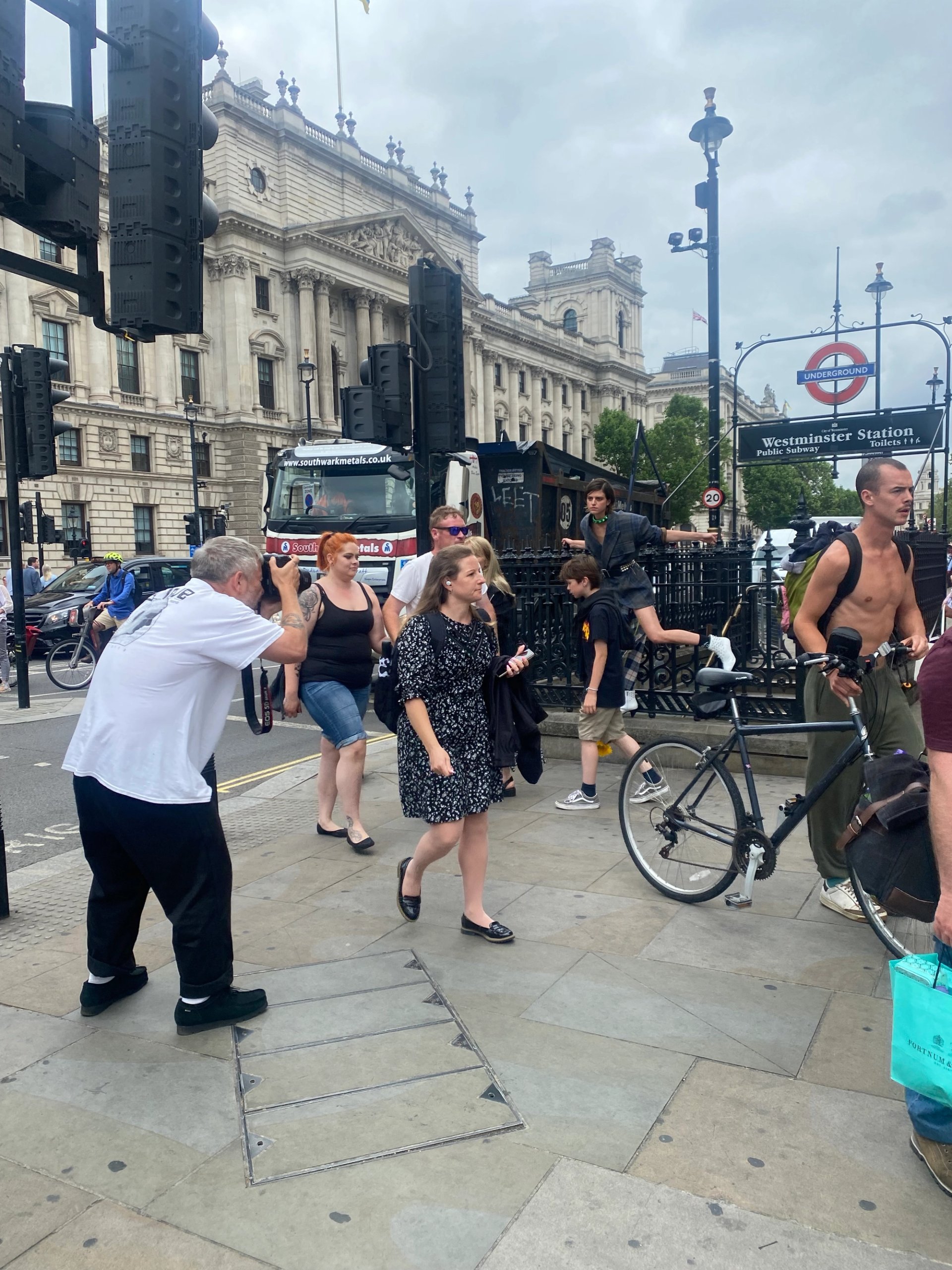 Street scene outside Westminster Station with photographer shooting and pedestrians passing by on location for Madame Figaro