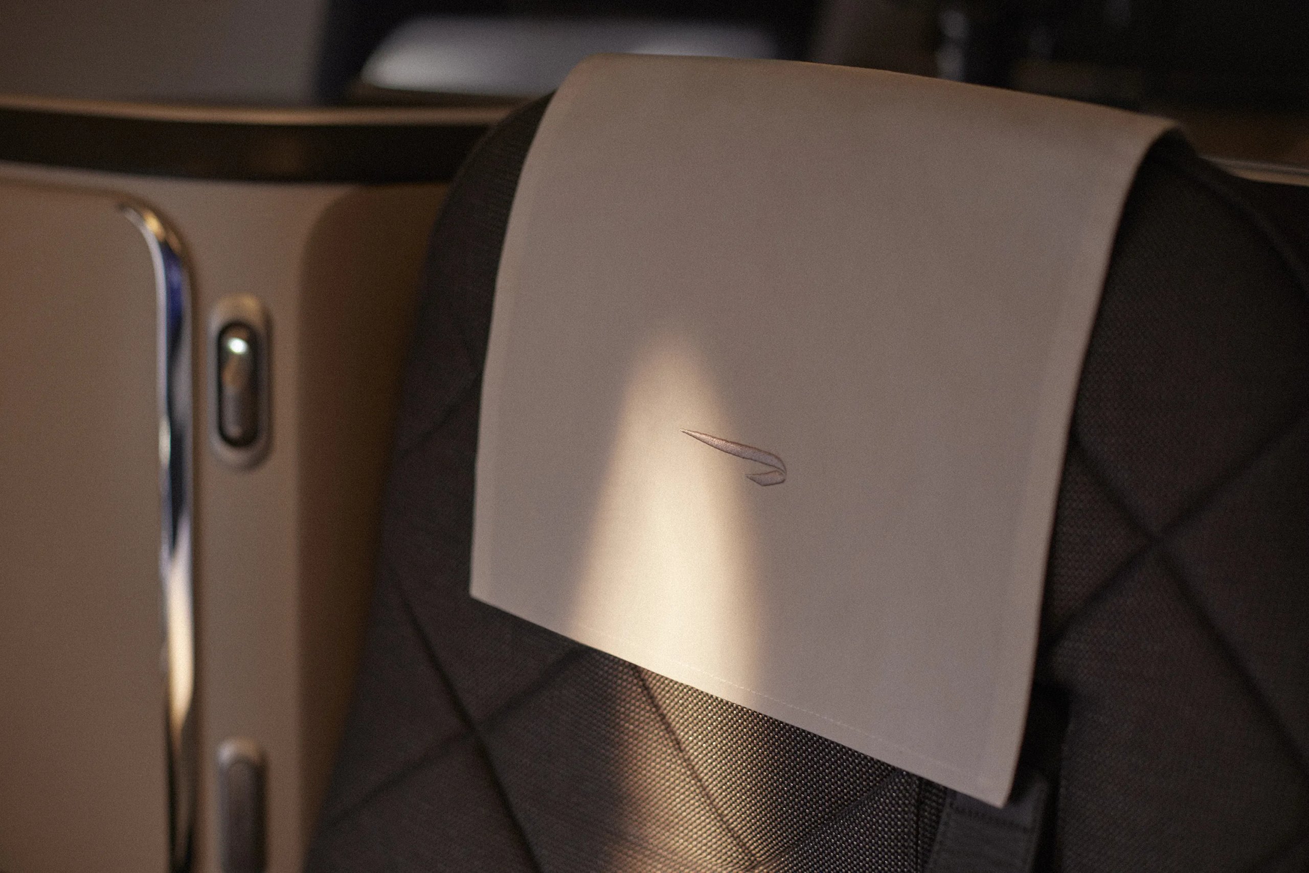 Close-up of British Airways premium cabin headrest with embossed speedmarque logo