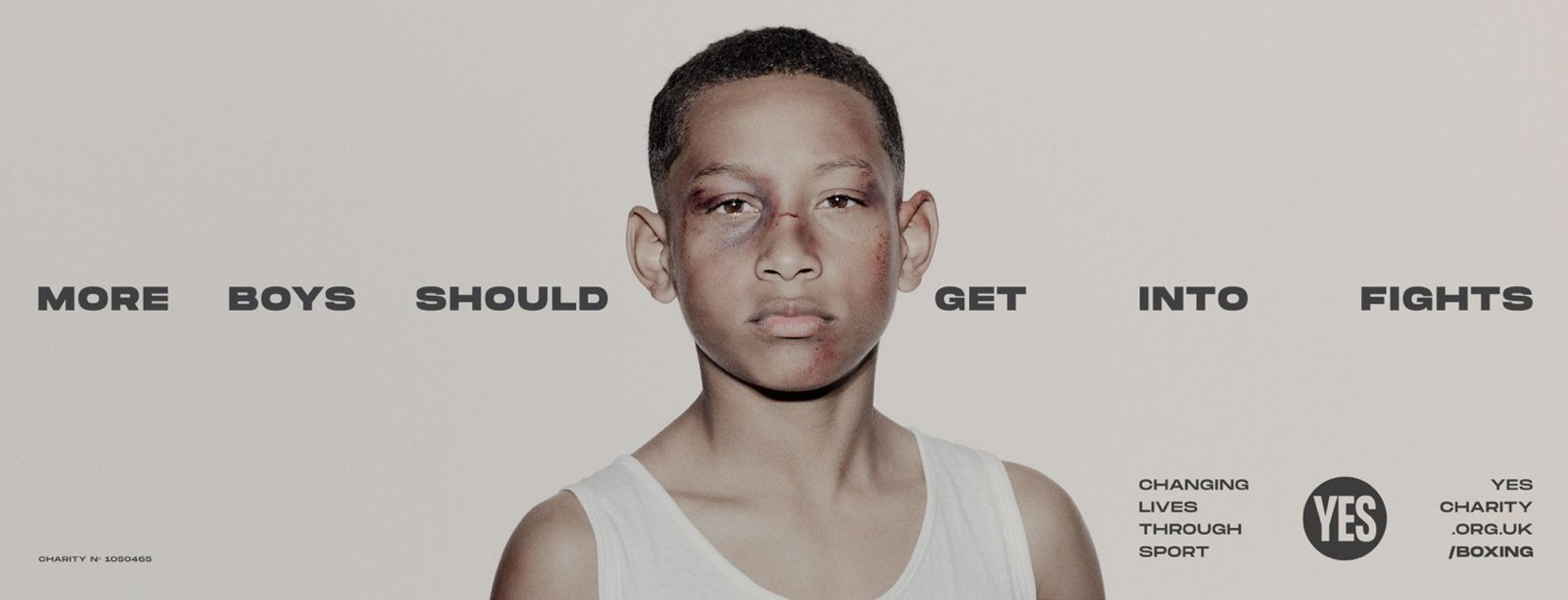 Young boy boxer with bruised face in YES! charity More Boys Should Get Into Fights campaign