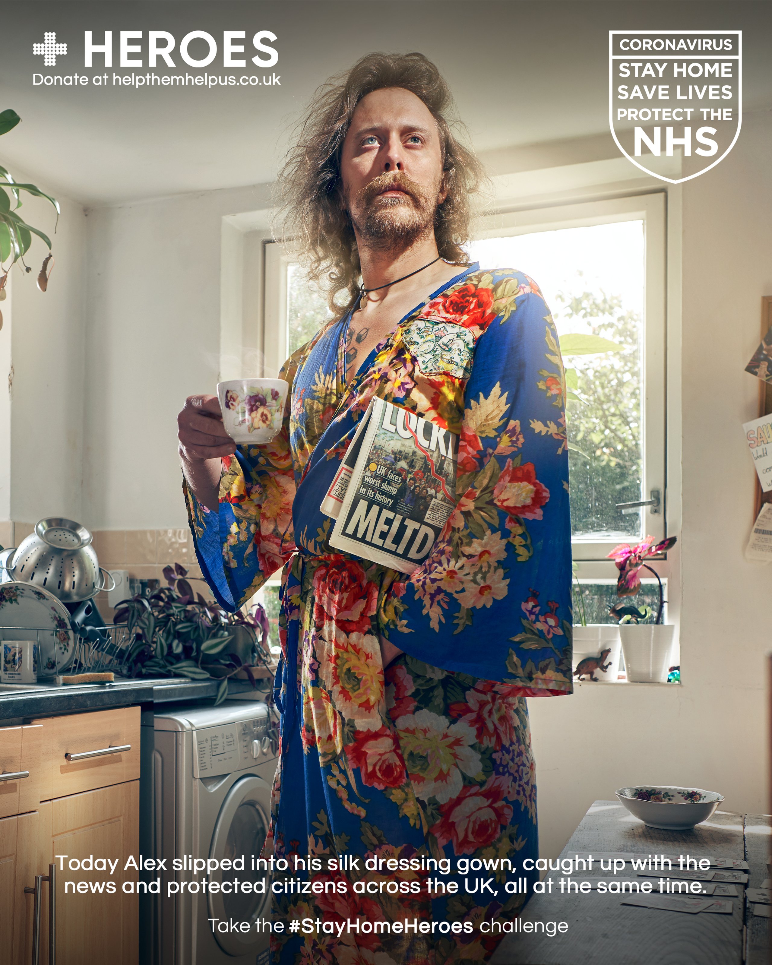Man in floral silk dressing gown holding tea and newspaper in kitchen for Stay Home Heroes