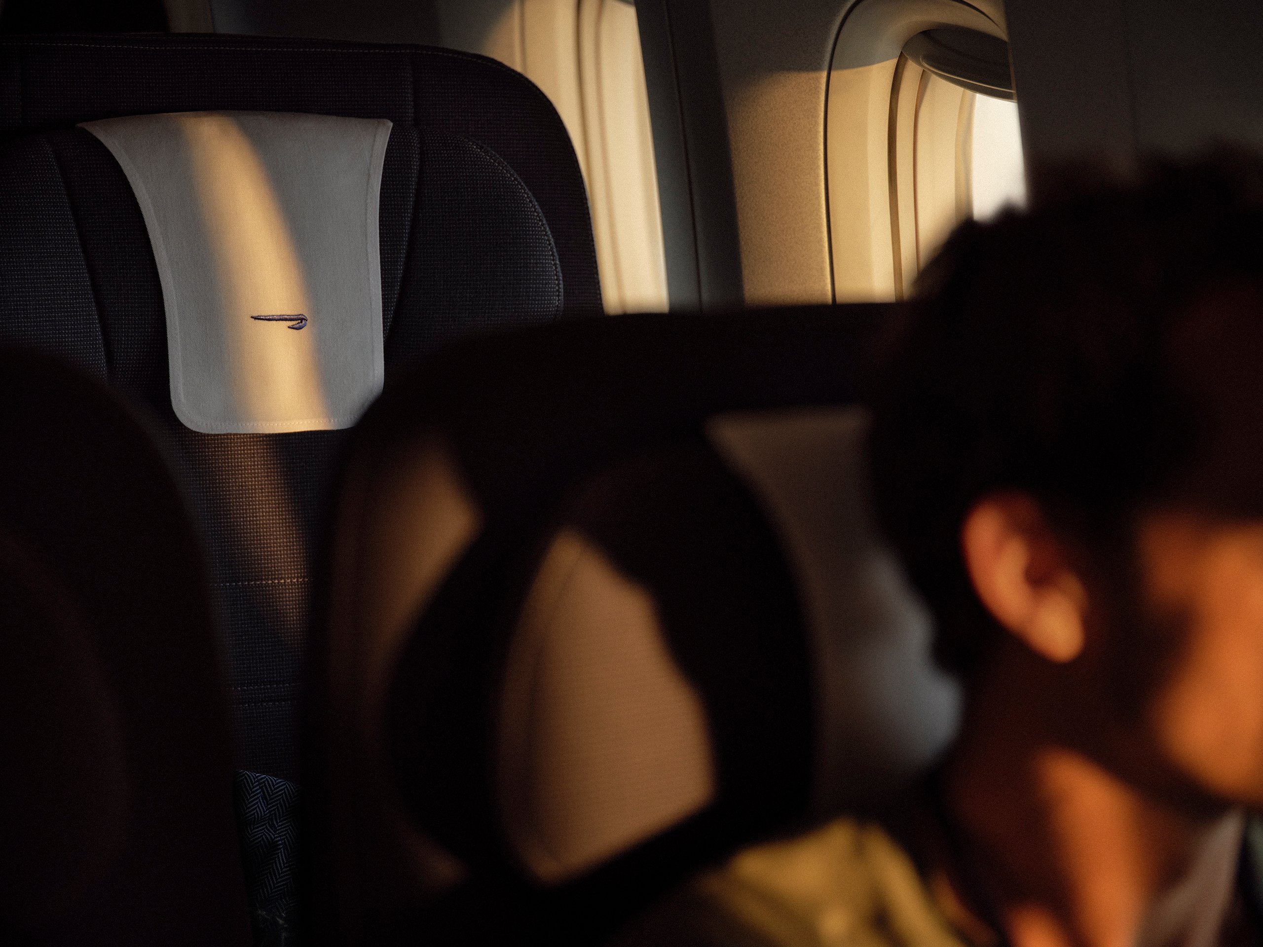 British Airways premium cabin headrest with embossed speedmarque logo and golden window light