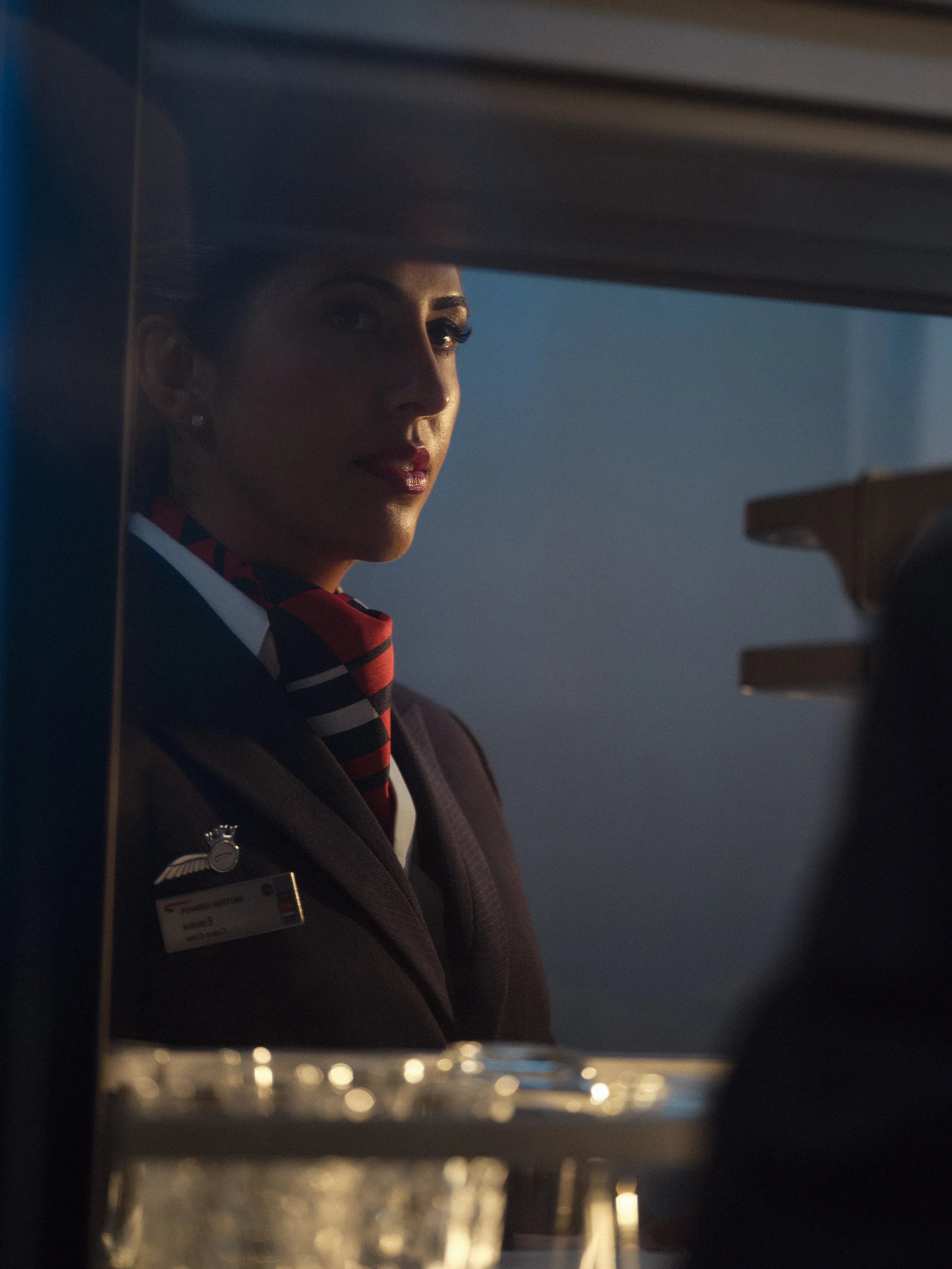 British Airways cabin crew member in uniform with striped scarf preparing service in galley