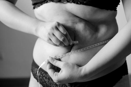 woman measuring her waist - If I Cut 1000 Calories A Day, How Much Weight Will I Lose