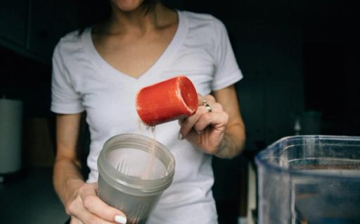 woman pouring in protein - Does Protein Turn Into Carbs