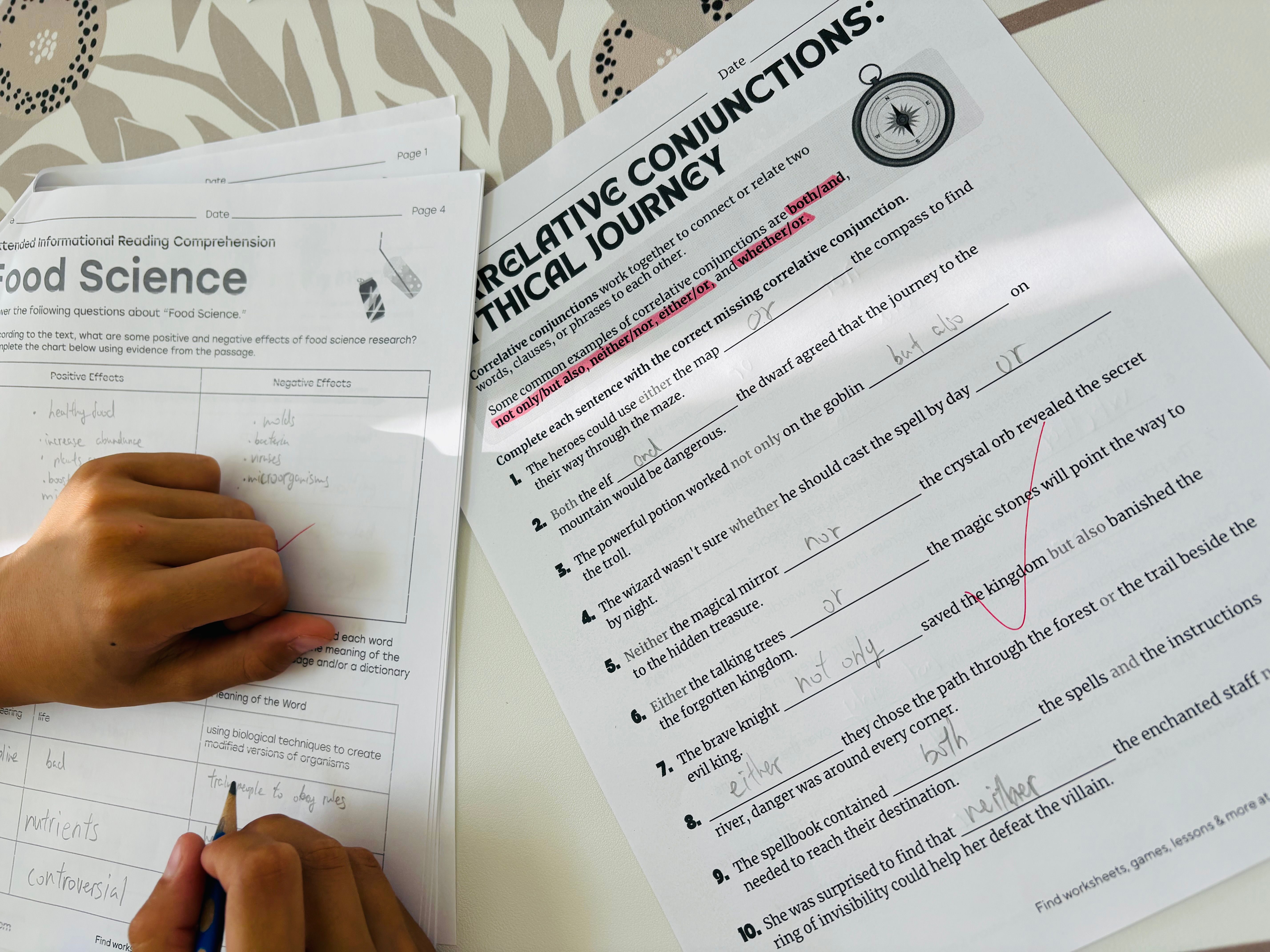 A child filling in a correlative-conjunctions worksheet in pencil, beside a reading-comprehension page on food science.