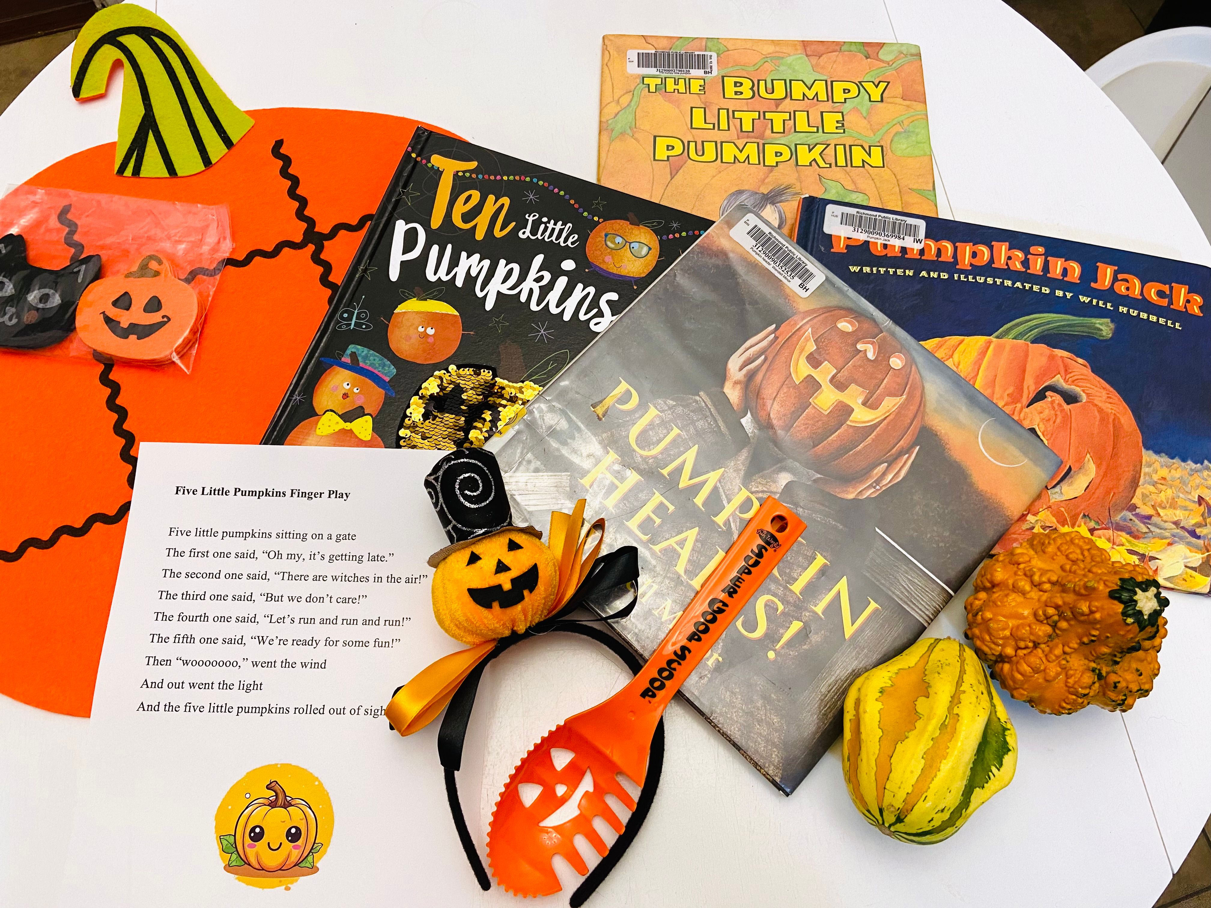 A pumpkin-themed storytime kit laid out on a table: picture books, a finger-play rhyme sheet, felt decorations, and gourds.