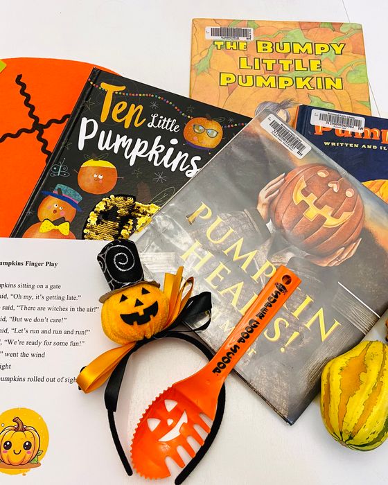 A pumpkin-themed storytime kit laid out on a table: picture books, a finger-play rhyme sheet, felt decorations, and gourds.